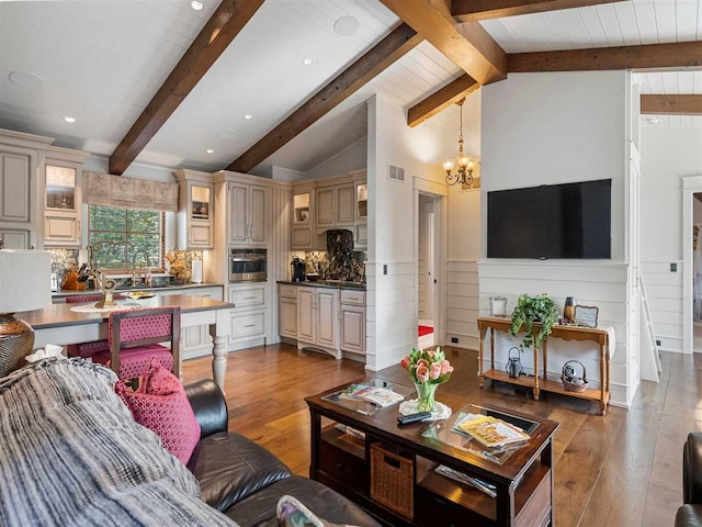 living room featuring an inviting chandelier, wood-type flooring, sink, and lofted ceiling with beams