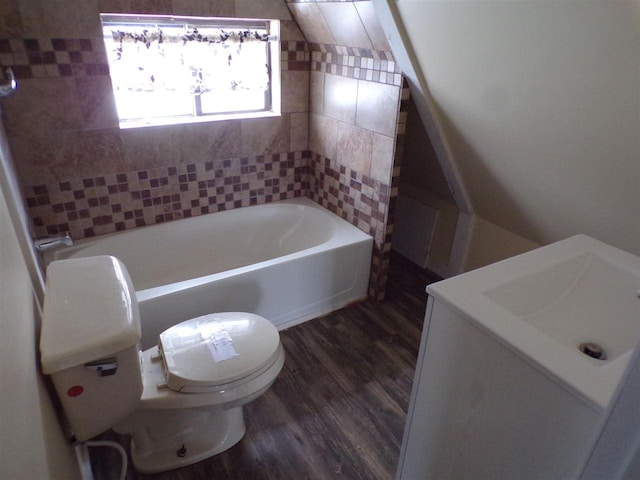 full bathroom with tiled shower / bath, vanity, toilet, and hardwood / wood-style floors