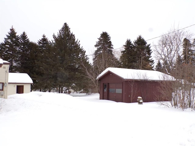 snow covered structure with a garage