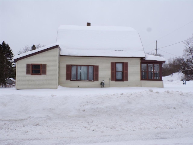 view of snow covered back of property