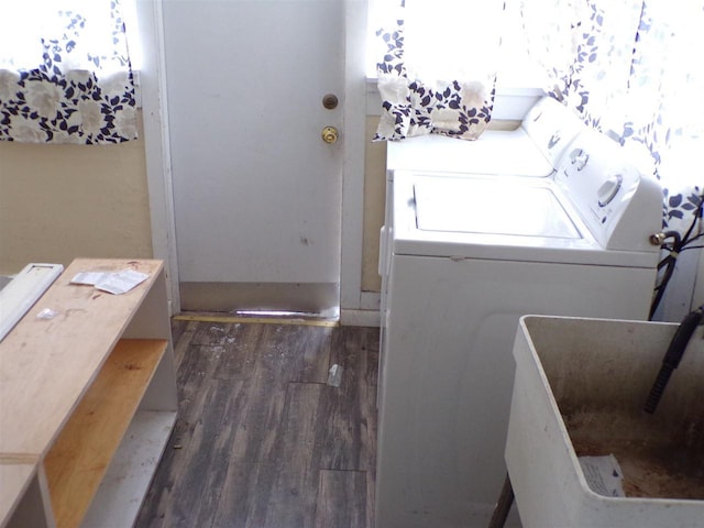 clothes washing area with separate washer and dryer, sink, and dark hardwood / wood-style flooring