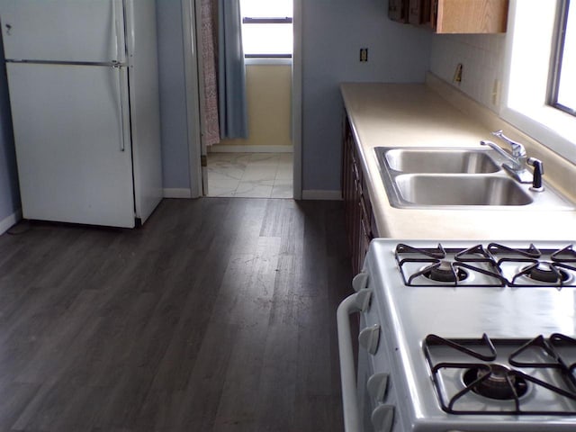 kitchen with white appliances, dark hardwood / wood-style floors, and sink