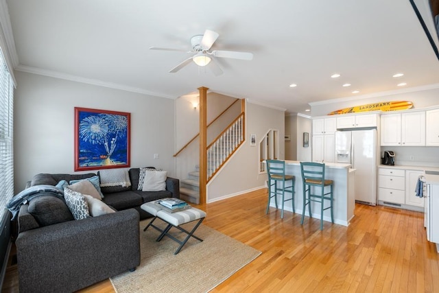 living room with crown molding, light wood-type flooring, recessed lighting, and stairs