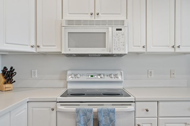 kitchen featuring white cabinetry, white appliances, and light countertops