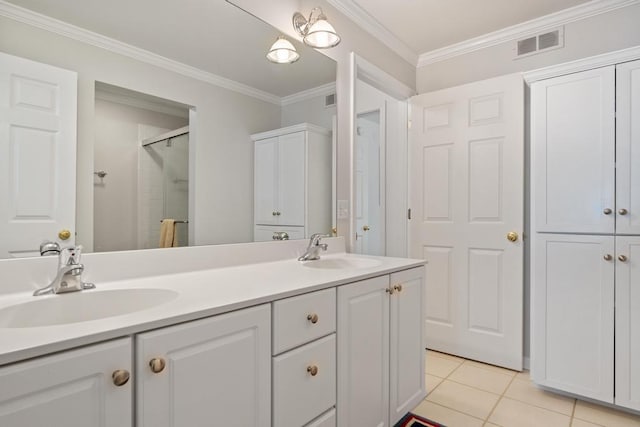 bathroom featuring tile patterned floors, a shower with shower door, visible vents, crown molding, and a sink