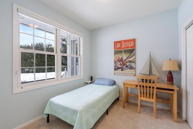 bedroom with light colored carpet and baseboards