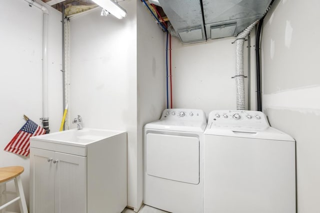 washroom with separate washer and dryer, laundry area, and a sink