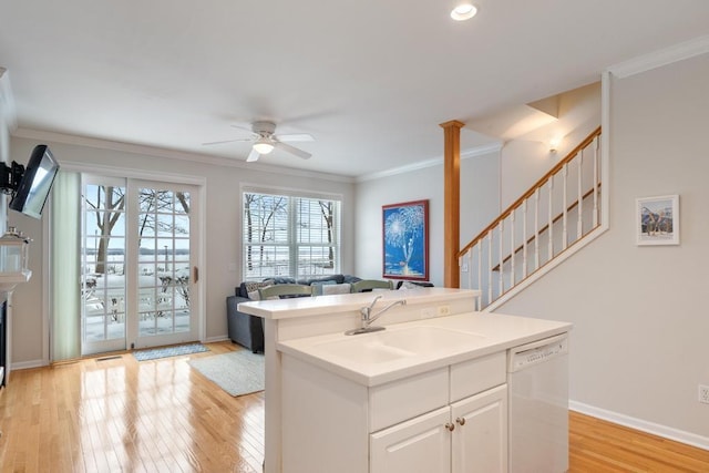 kitchen with light countertops, white dishwasher, open floor plan, white cabinetry, and a sink