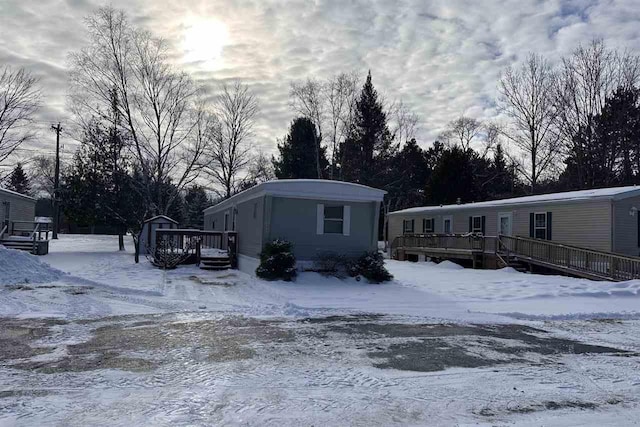 snow covered property with a wooden deck