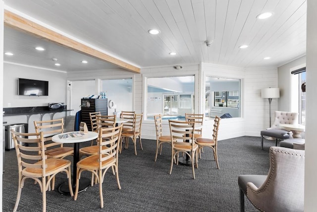 carpeted dining room with vaulted ceiling with beams and wooden ceiling