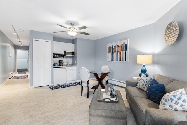 living room featuring light hardwood / wood-style flooring, a baseboard radiator, and ceiling fan