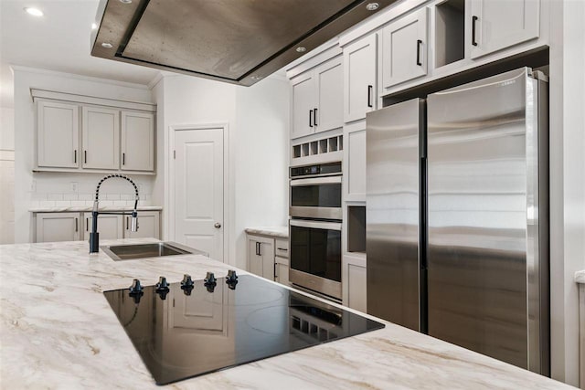 kitchen featuring appliances with stainless steel finishes, sink, and light stone counters