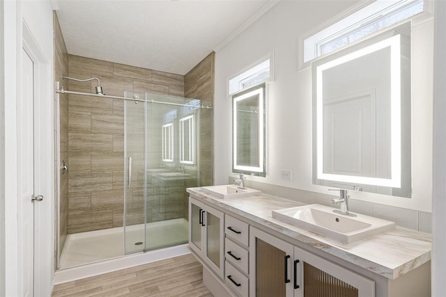 bathroom with a shower with door, vanity, and hardwood / wood-style floors