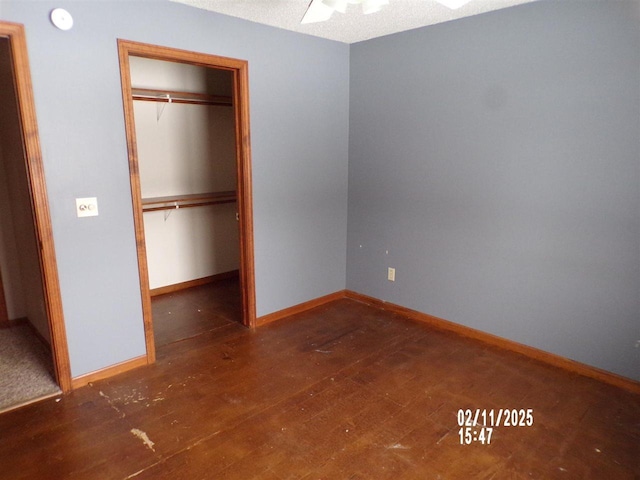 unfurnished bedroom with dark hardwood / wood-style flooring and a closet