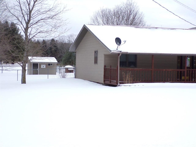 view of snowy exterior featuring covered porch