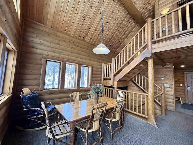 carpeted dining area featuring wood ceiling, high vaulted ceiling, and log walls