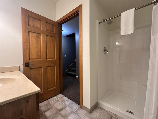 bathroom with tile patterned floors, vanity, and a shower