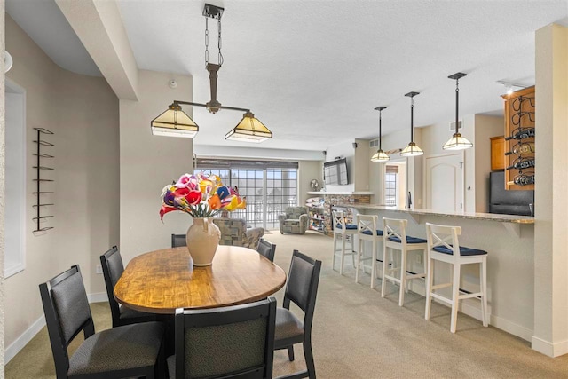 dining area with light colored carpet and a textured ceiling