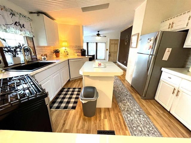 kitchen with white cabinets, appliances with stainless steel finishes, sink, and light hardwood / wood-style flooring