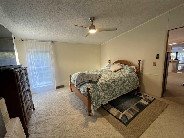 bedroom with a textured ceiling, ornamental molding, light colored carpet, and ceiling fan