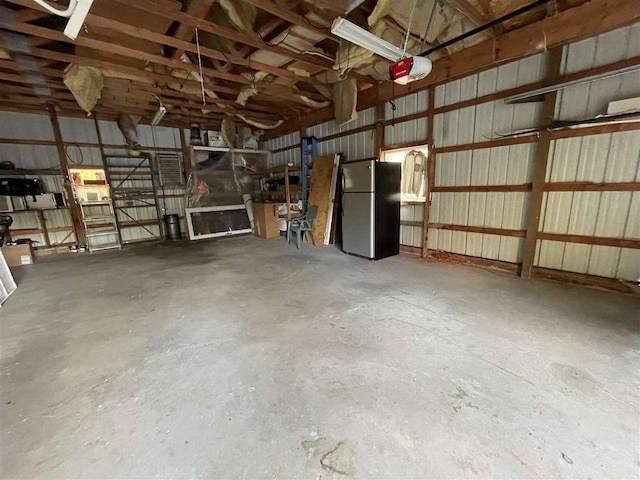 garage with a garage door opener and stainless steel fridge