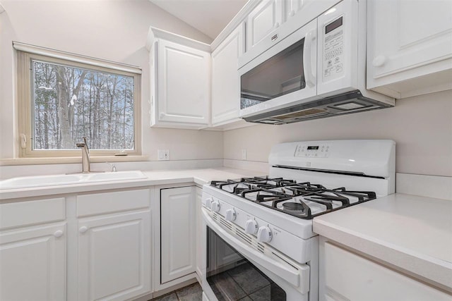 kitchen featuring sink, white appliances, white cabinets, and lofted ceiling