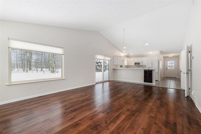 unfurnished living room with high vaulted ceiling and dark hardwood / wood-style floors