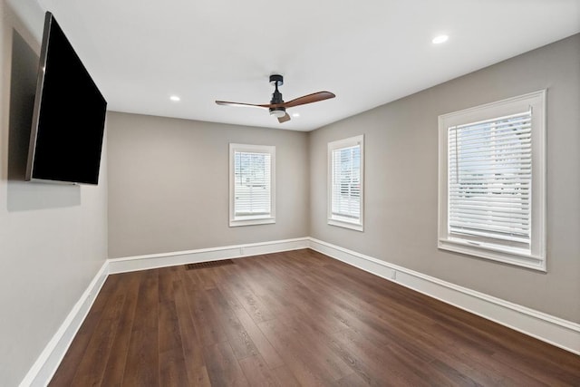 empty room with dark wood-style floors, recessed lighting, ceiling fan, and baseboards