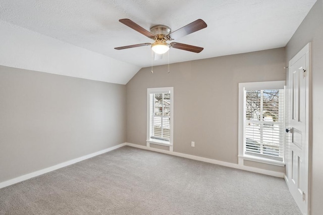 bonus room with lofted ceiling, a healthy amount of sunlight, and light colored carpet