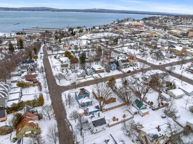 snowy aerial view with a water view and a residential view