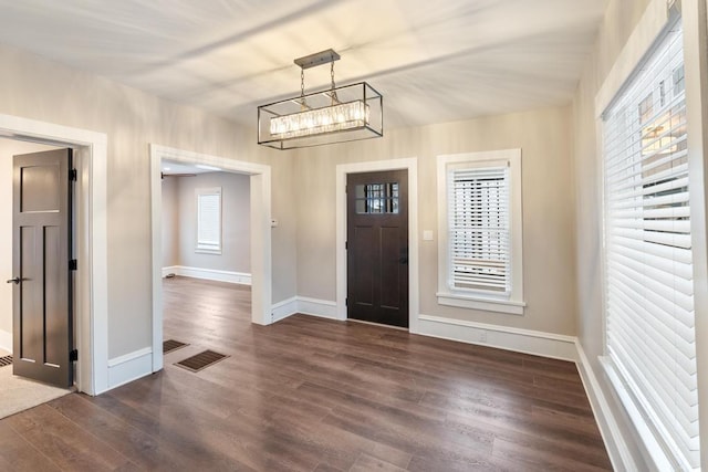 foyer entrance featuring visible vents, dark wood finished floors, and baseboards