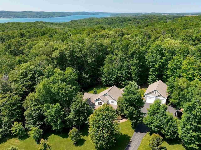 birds eye view of property featuring a forest view and a water view