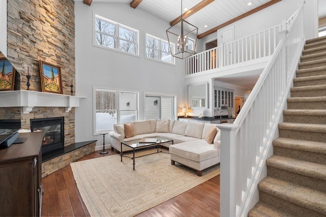 2632 Woodside Dr, Petoskey, MI 49770 - living room featuring a fireplace, a notable chandelier, wood finished floors, beamed ceiling, and stairs