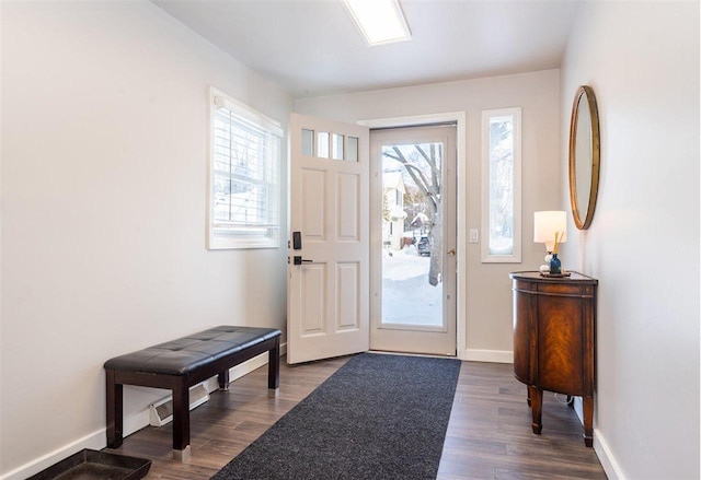 entryway with a healthy amount of sunlight, baseboards, and dark wood finished floors