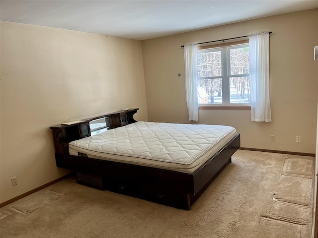 bedroom featuring light colored carpet and baseboards