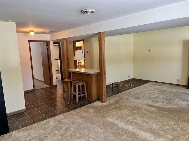 unfurnished room with dark colored carpet, dark tile patterned flooring, visible vents, and baseboards