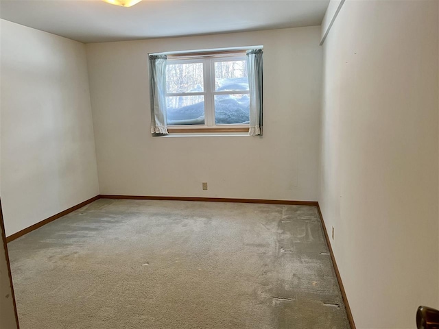 spare room with baseboards and carpet flooring