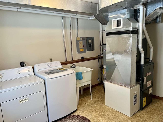 laundry area with laundry area, electric panel, visible vents, baseboards, and washer and clothes dryer