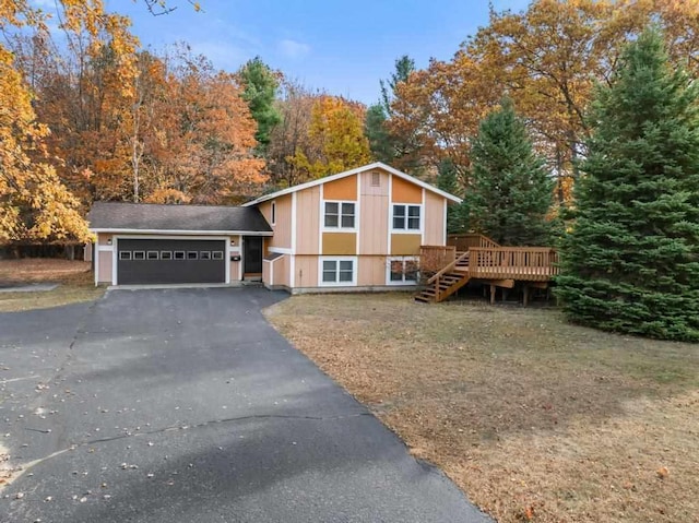 split level home with an attached garage, stairs, aphalt driveway, and a wooden deck