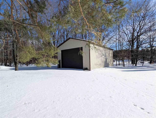 snow covered garage with a garage