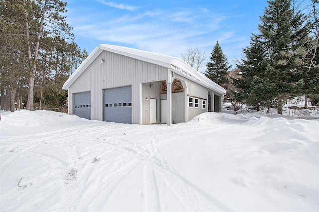 snow covered garage with a detached garage