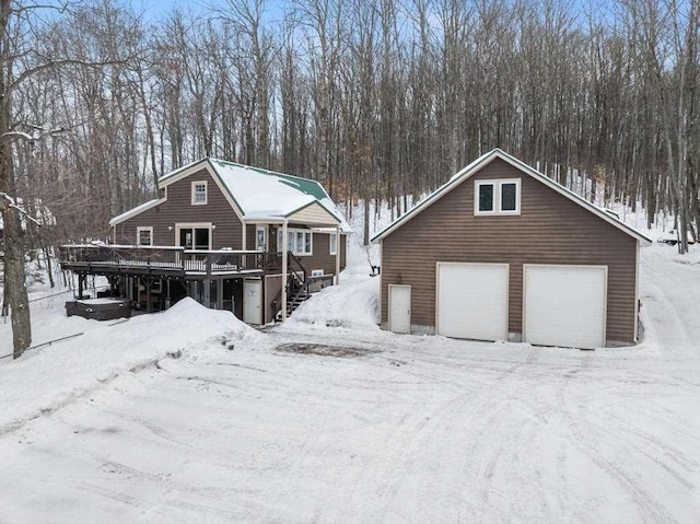 view of front of property with a garage, stairway, an outbuilding, and a wooden deck