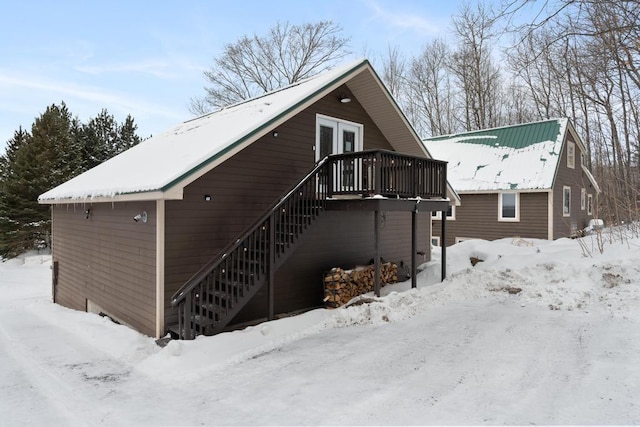 snow covered property featuring stairway and a deck