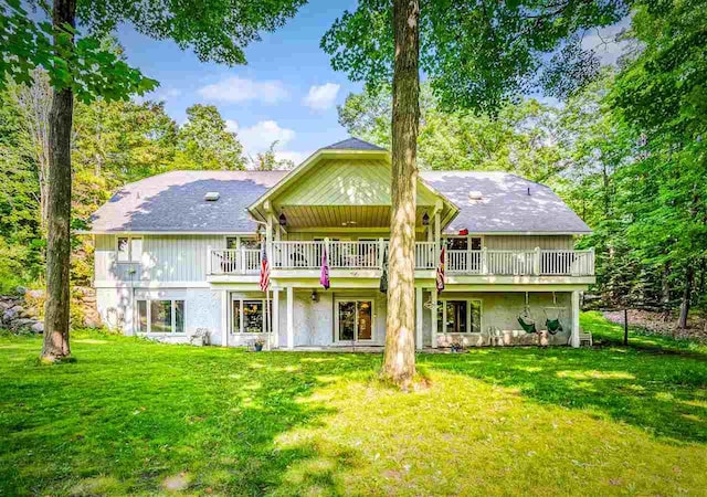 back of property featuring a deck and a lawn