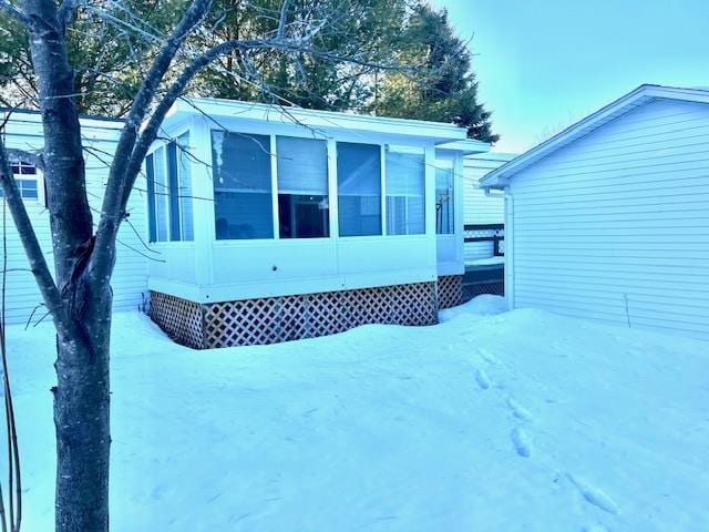 snow covered property with a sunroom