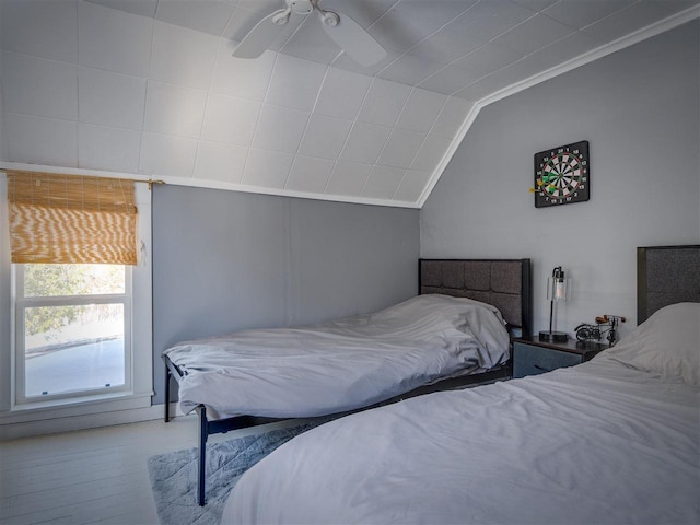 bedroom featuring lofted ceiling, crown molding, and wood finished floors