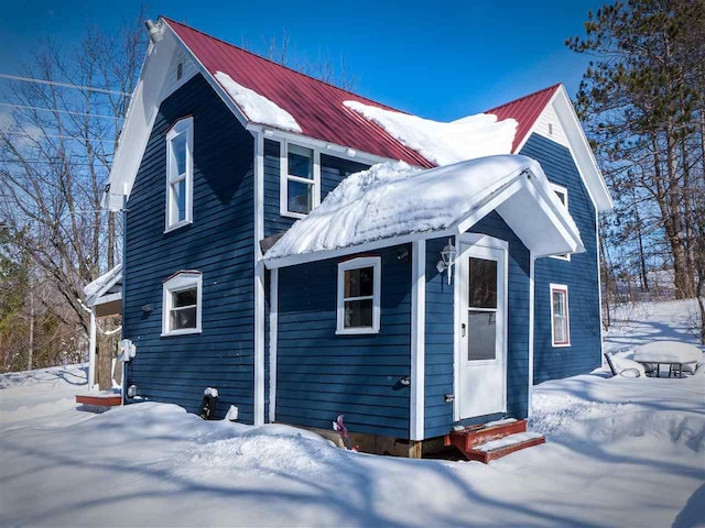 exterior space with entry steps and metal roof