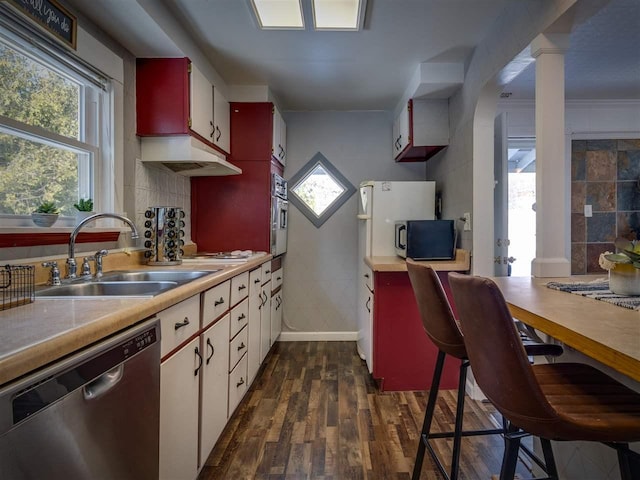 kitchen with appliances with stainless steel finishes, a wealth of natural light, light countertops, and a sink