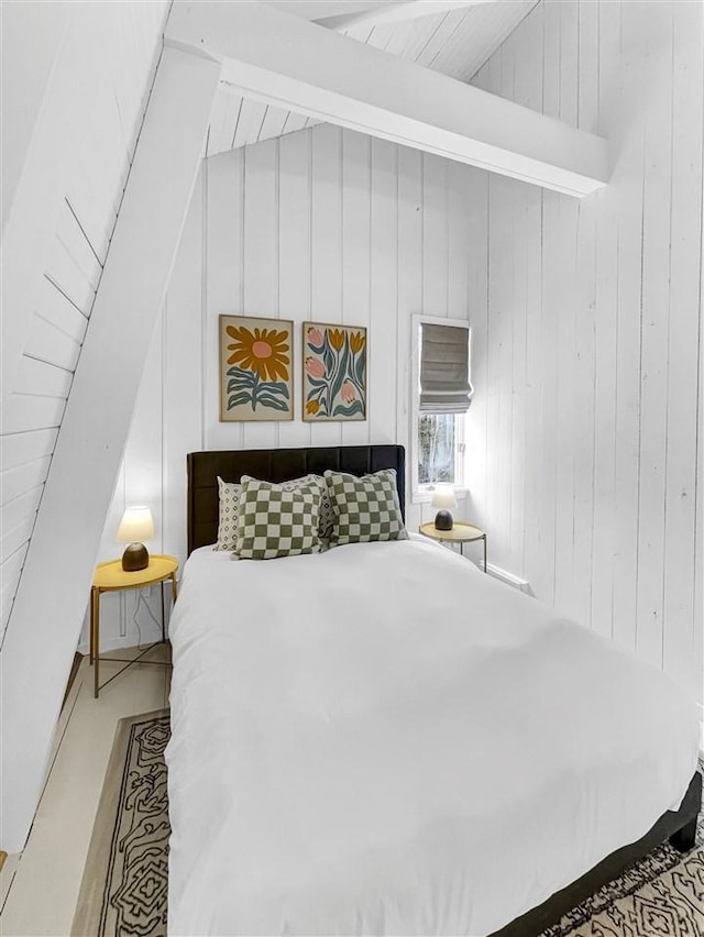 bedroom featuring lofted ceiling with beams and wood walls