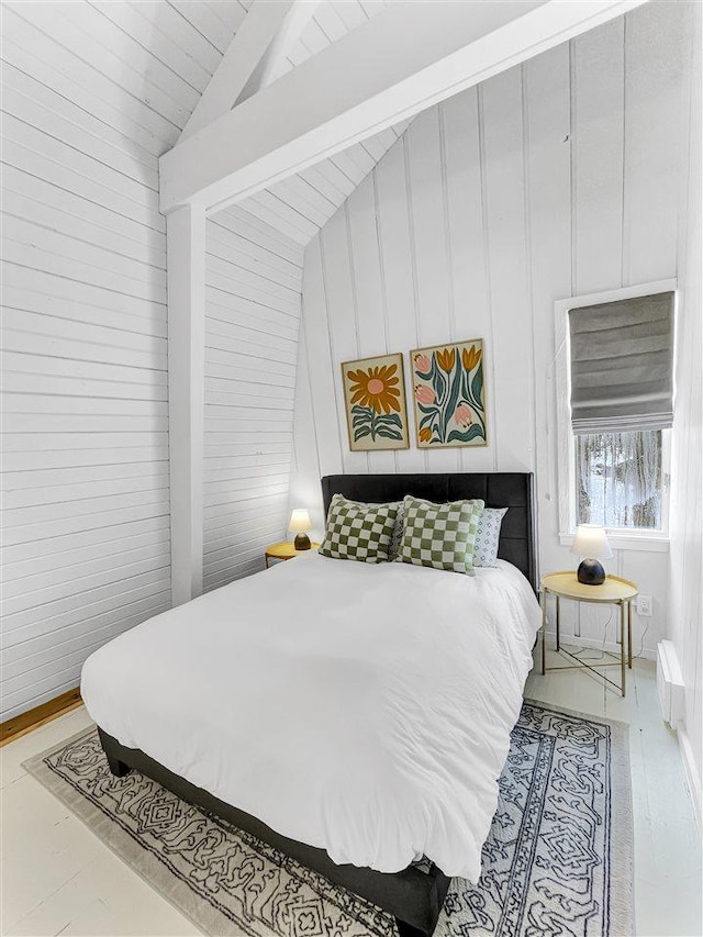 bedroom with lofted ceiling and wood walls